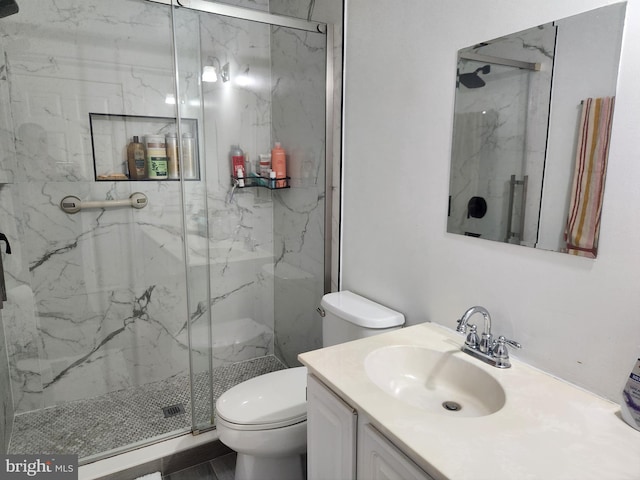 bathroom featuring vanity, an enclosed shower, and toilet