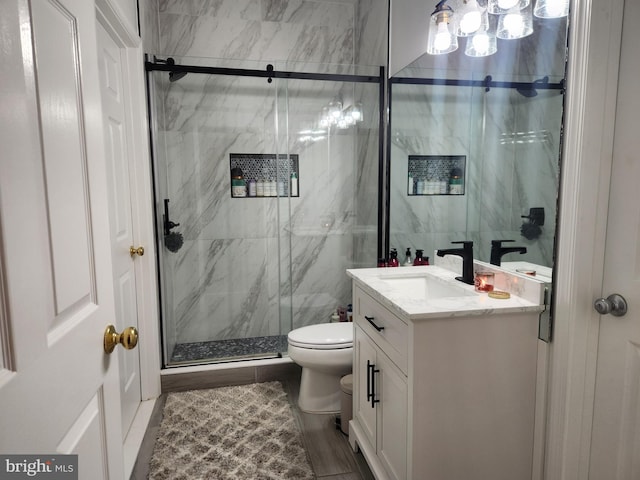 bathroom featuring vanity, toilet, tile walls, and walk in shower