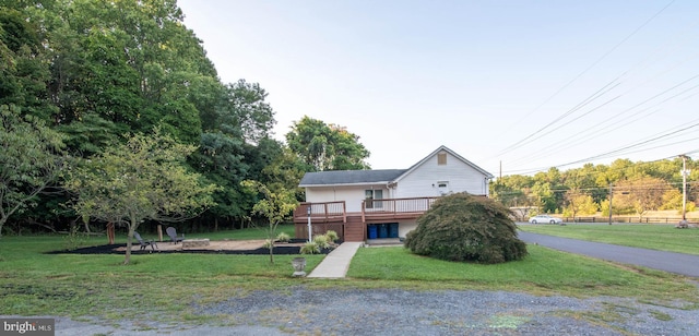 view of front facade with a front lawn and a deck