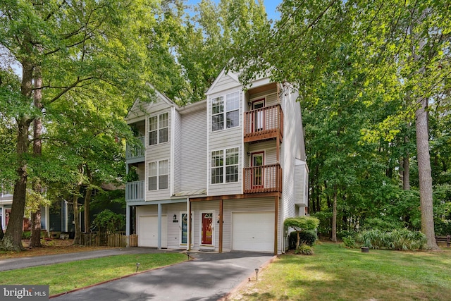 townhome / multi-family property featuring a garage, a front lawn, and a balcony