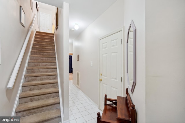 stairway with tile patterned floors