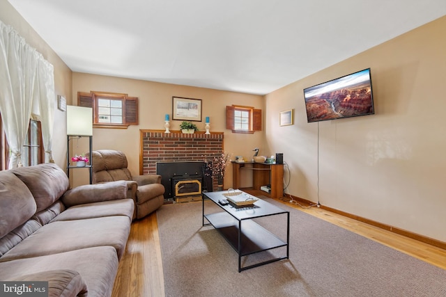 living room with light hardwood / wood-style flooring and a brick fireplace