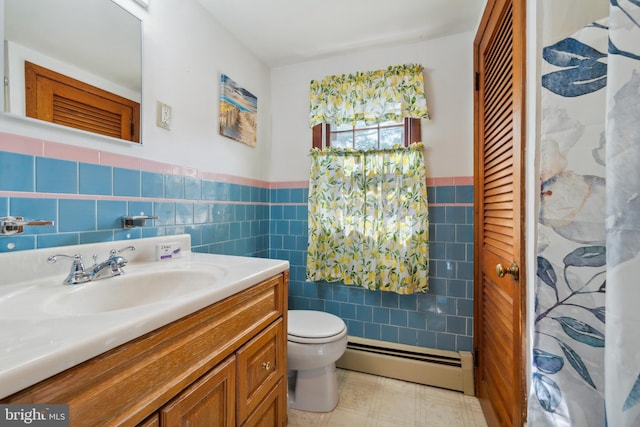 bathroom with tile walls, decorative backsplash, vanity, toilet, and a baseboard heating unit