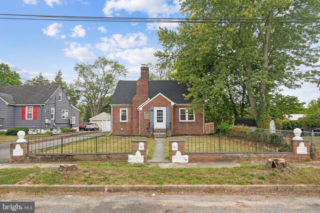 view of front facade featuring an outdoor structure, a garage, and a front yard