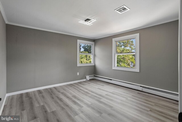 unfurnished room with light wood-type flooring, ornamental molding, and a baseboard heating unit