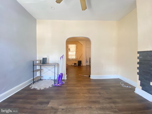 empty room with dark wood-type flooring, ceiling fan, and lofted ceiling