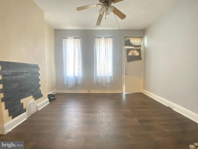 unfurnished living room with dark hardwood / wood-style flooring and ceiling fan