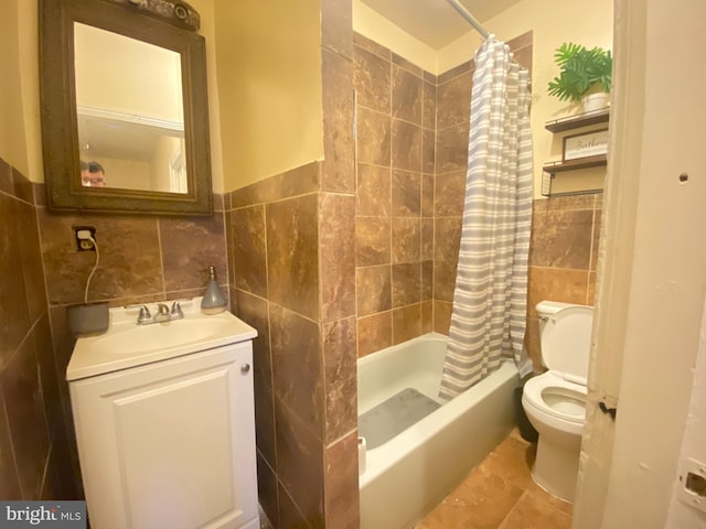 full bathroom featuring vanity, toilet, shower / tub combo, and tile walls