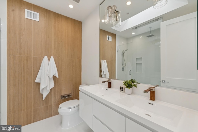 bathroom featuring tile patterned flooring, vanity, an enclosed shower, and toilet