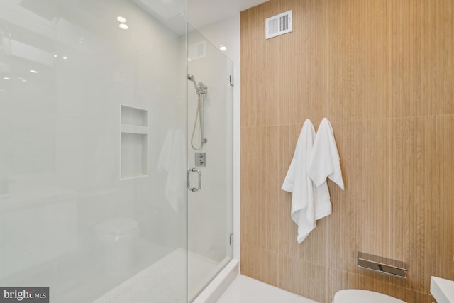 bathroom with toilet and a shower with shower door