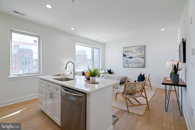 kitchen with dishwasher, light hardwood / wood-style flooring, white cabinetry, sink, and an island with sink