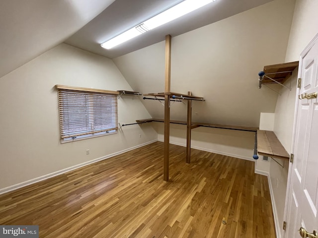 walk in closet featuring wood finished floors and lofted ceiling