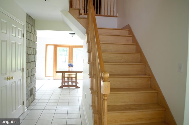 staircase featuring tile patterned flooring
