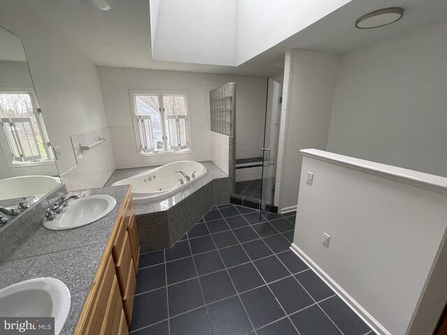 bathroom featuring a sink, a tub with jets, a stall shower, tile patterned flooring, and double vanity