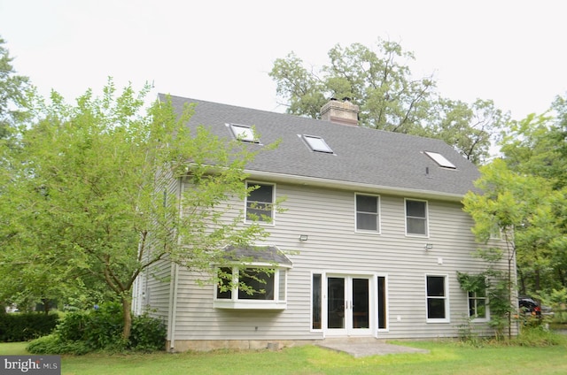 rear view of property with a yard, french doors, and a chimney