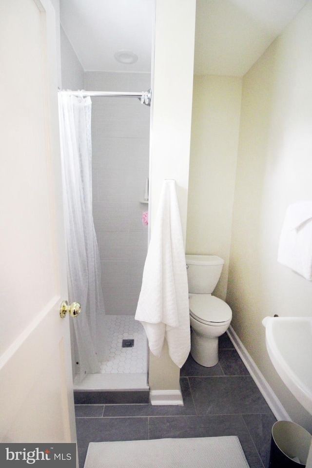 bathroom featuring walk in shower, tile patterned flooring, and toilet