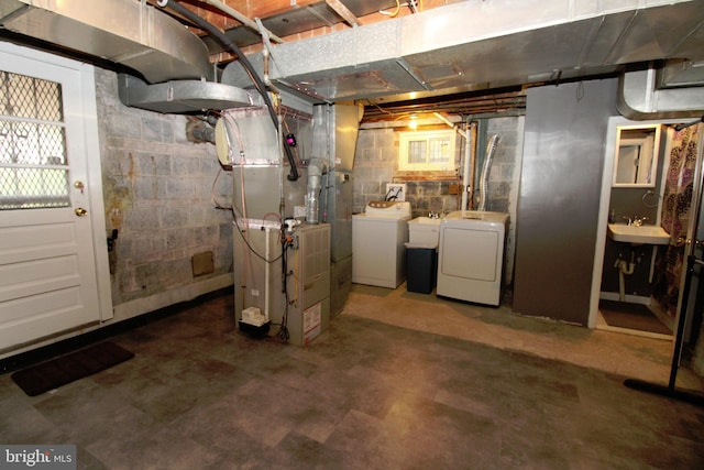 basement with washing machine and dryer, sink, and heating unit