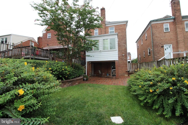 back of house with a lawn and a patio area