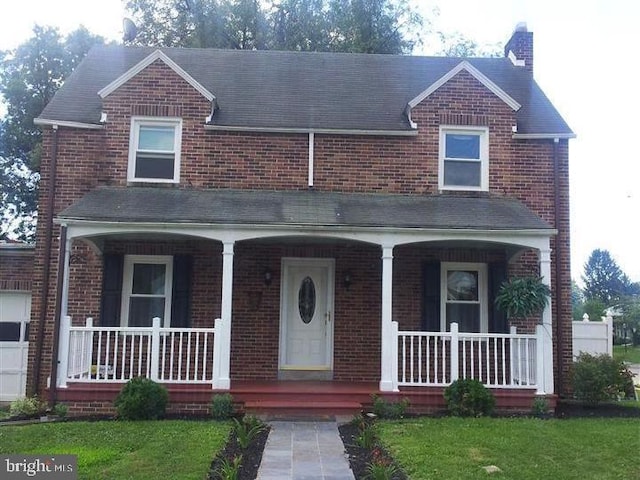 view of front of property featuring a front lawn and a porch