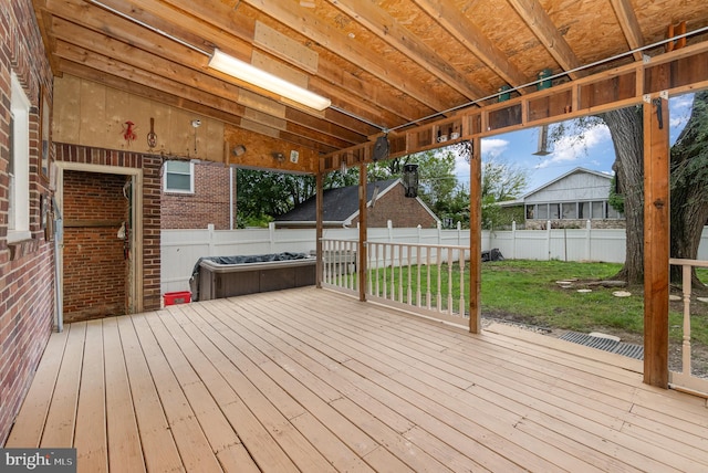 wooden terrace with a hot tub and a yard