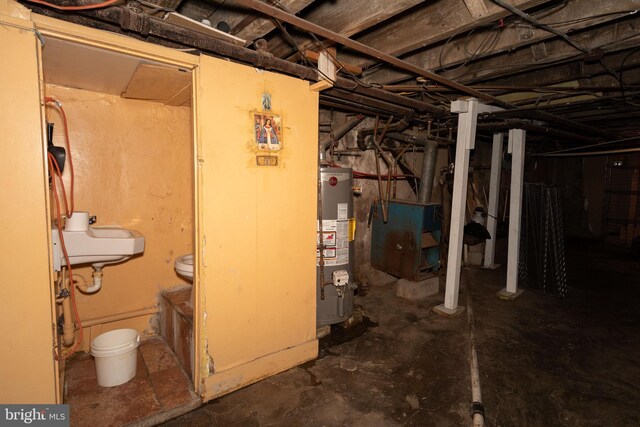 basement featuring gas water heater and sink