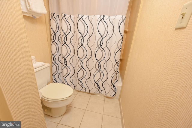 bathroom with shower / bathtub combination with curtain, toilet, and tile patterned floors