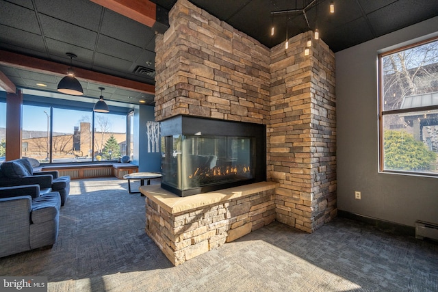 living room with a fireplace, a wealth of natural light, a paneled ceiling, and carpet floors