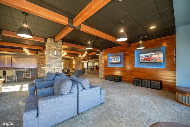 living room featuring carpet flooring, a paneled ceiling, and wood walls