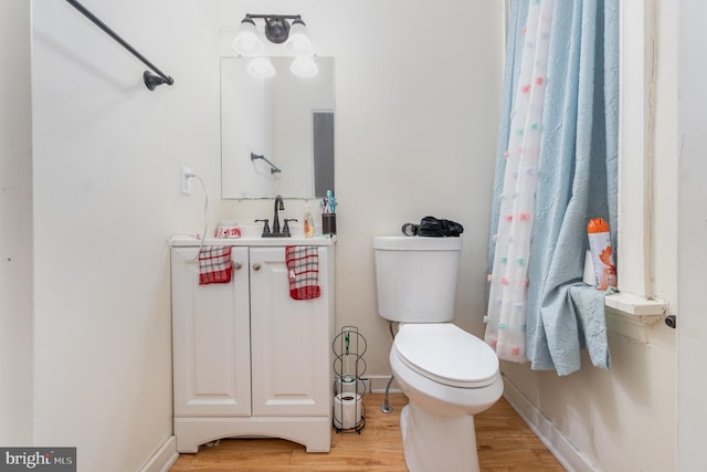 bathroom with vanity, toilet, and wood-type flooring