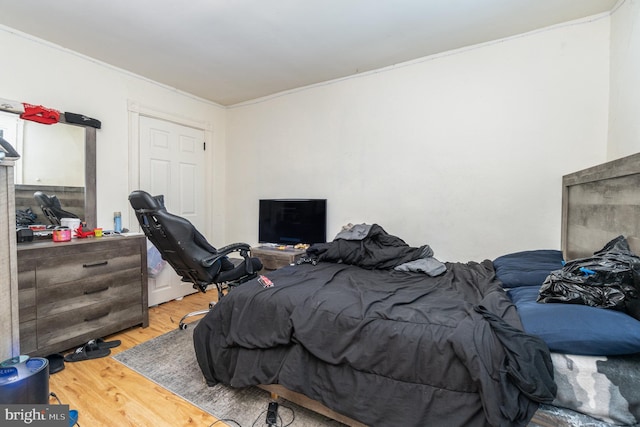 bedroom with hardwood / wood-style flooring and crown molding