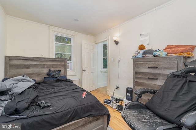 bedroom with ornamental molding and hardwood / wood-style flooring