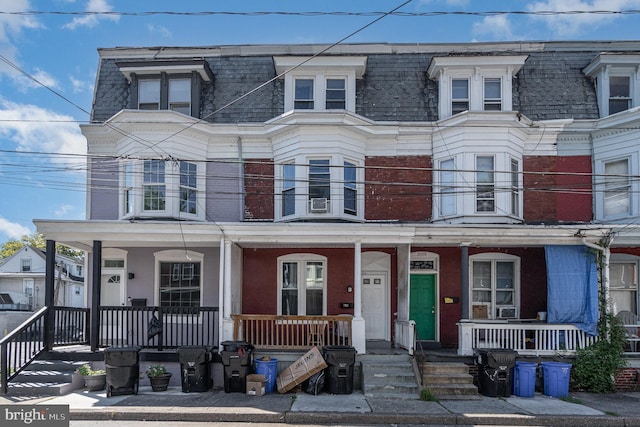 view of property with a balcony and covered porch