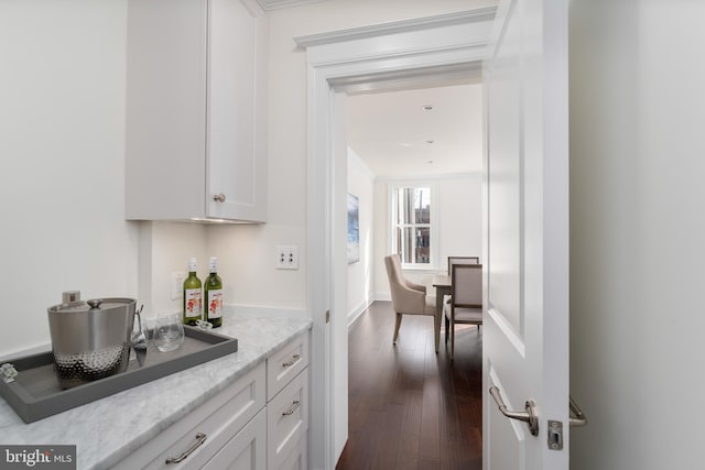 kitchen featuring light stone counters, dark wood-type flooring, and white cabinetry