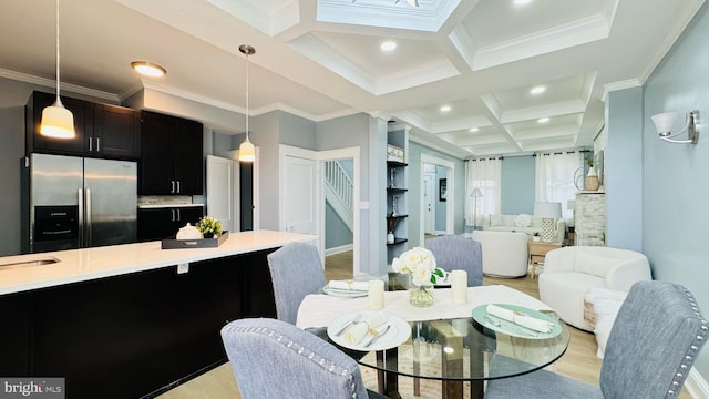 dining room featuring crown molding, coffered ceiling, light hardwood / wood-style flooring, and beam ceiling