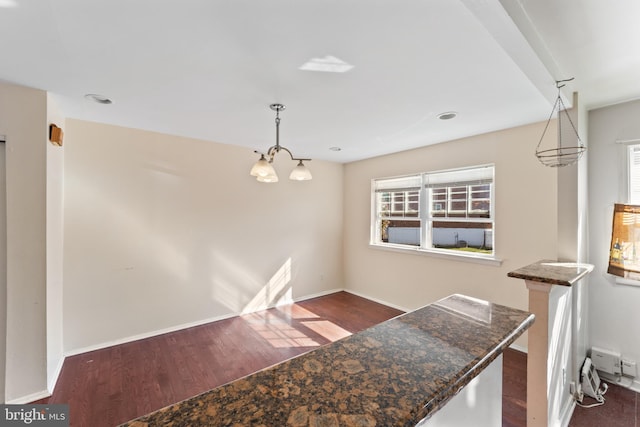 interior space with pendant lighting, dark hardwood / wood-style flooring, and a healthy amount of sunlight