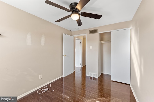 unfurnished bedroom with ceiling fan, a closet, and dark hardwood / wood-style floors