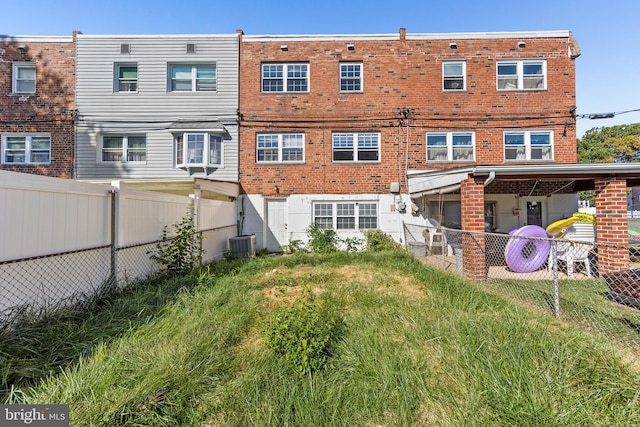 back of house with cooling unit and a yard