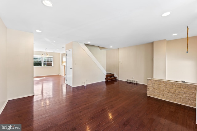 unfurnished room with dark wood-type flooring and a notable chandelier