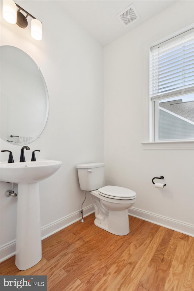 bathroom featuring wood-type flooring and toilet