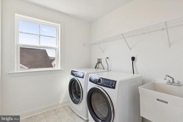 laundry room with separate washer and dryer, sink, and light tile patterned floors