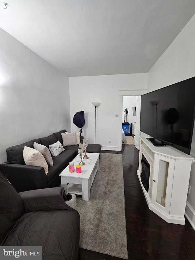 living room featuring lofted ceiling and dark hardwood / wood-style flooring