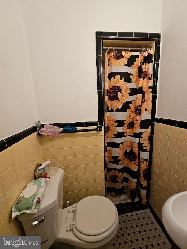 bathroom featuring walk in shower, tile walls, tile patterned flooring, and toilet