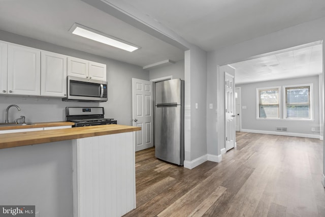 kitchen featuring white cabinetry, wooden counters, sink, dark hardwood / wood-style floors, and appliances with stainless steel finishes