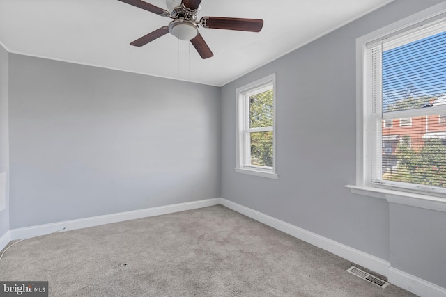 spare room with light carpet, crown molding, and ceiling fan