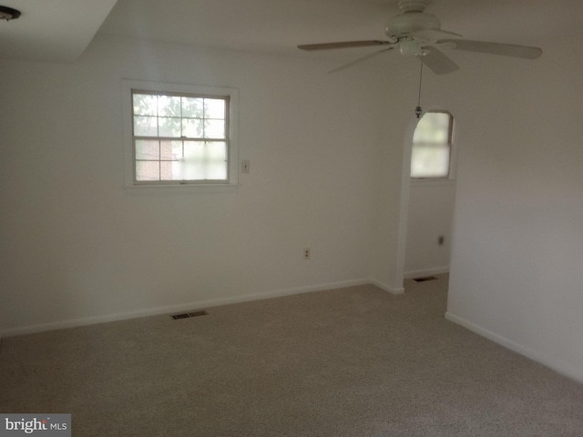 carpeted spare room featuring ceiling fan