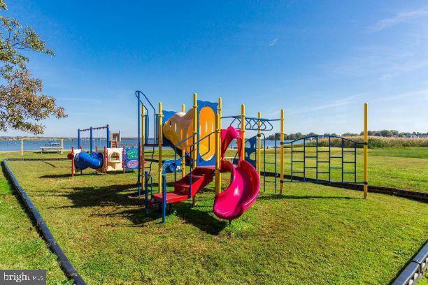 view of jungle gym with a yard and a water view