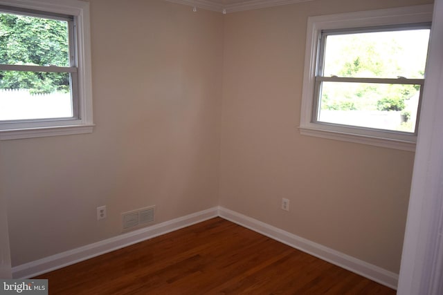 spare room with plenty of natural light, ornamental molding, and hardwood / wood-style flooring