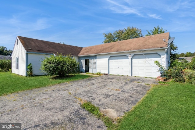 ranch-style home featuring a front lawn and a garage