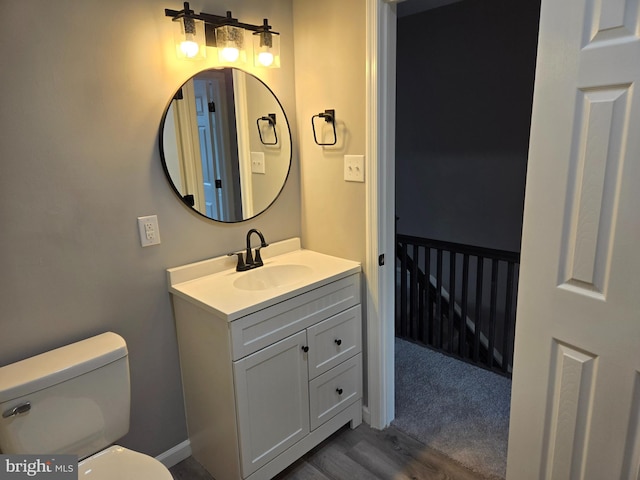 bathroom featuring vanity, toilet, and hardwood / wood-style floors