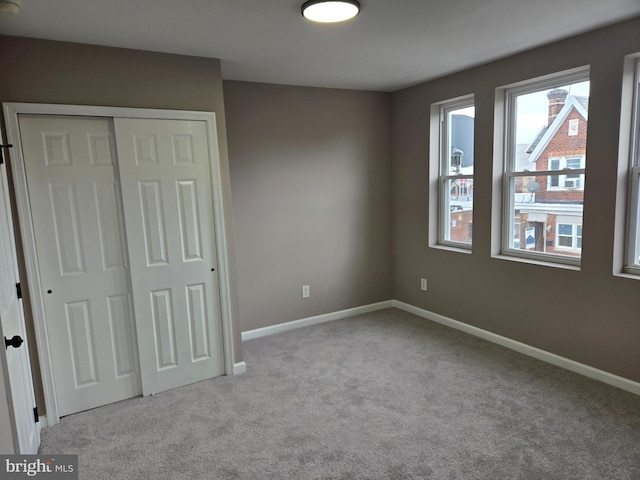 unfurnished bedroom featuring a closet and light carpet